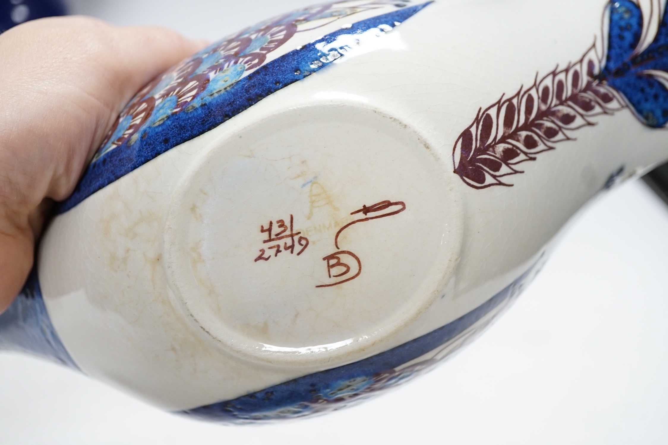 Two Danish ceramic items designed by Bjorn Wiinblad; a lidded pedestal cup in the form of a head with large hat and a candlestick, 26cm high, together with a bird sauce boat signed BJ on base (Berte Jesson)